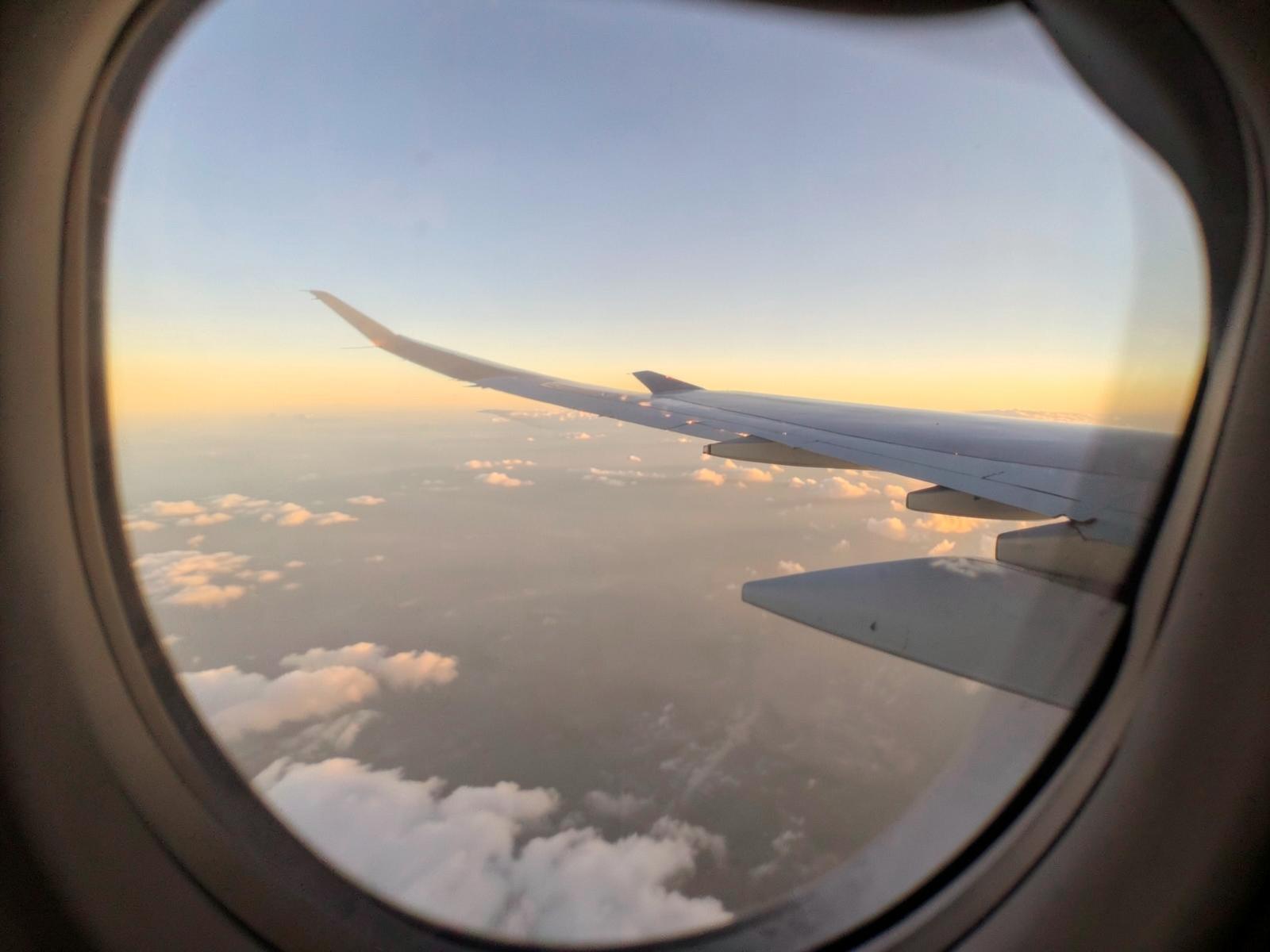 Vista del ala de un avión desde la ventanilla al atardecer